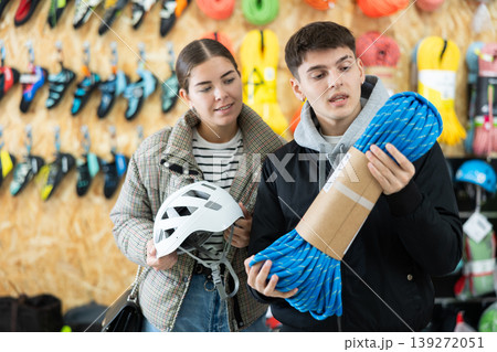 Guy and girl view rope cable for climbing and evaluate its thickness 139272051