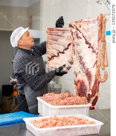 Adult male butcher holding beef ribs Adult male butcher holding beef ribs 139272079