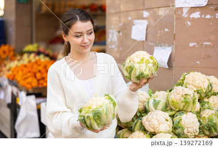 Young woman choosing cauliflower at vegetable market Young woman choosing cauliflower at vegetable market 139272169