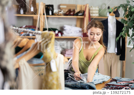 Young woman scanning barcode of jeans in store Young woman scanning barcode of jeans in store 139272175