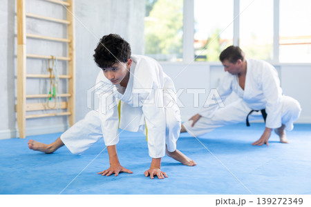Man and boy teenager doing stretching in studio Man and boy teenager doing stretching in studio 139272349