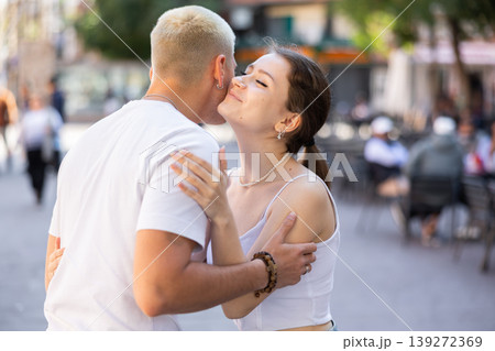 guy and a girl kiss on the cheek when they meet 139272369