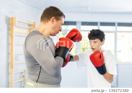 Father teaches son to box during individual boxing training in gym 139272380