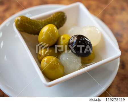 Bowl is filled with pickled vegetables - olives, small onions, gherkins Bowl is filled with pickled vegetables - olives, small onions, gherkins 139272429