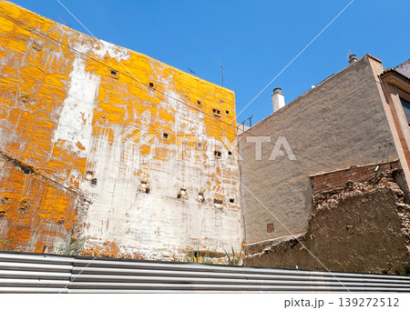 Exposed Building Side Wall with Yellow Protective Coating in Urban Area 139272512