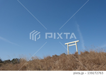 青空の下に佇む白い鳥居と丘の風景・コピースペースの広いミニマルな和のイメージ 139272763