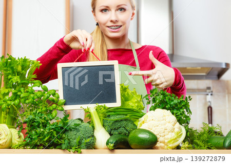 Woman having green vegetables holding board Woman having green vegetables holding board 139272879