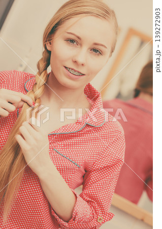 Woman doing braid on blonde hair Woman doing braid on blonde hair 139272903
