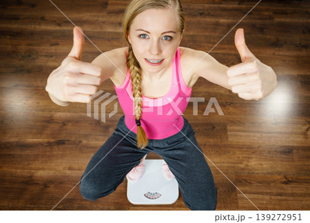 Teenage woman on bathroom scale machine Teenage woman on bathroom scale machine 139272951