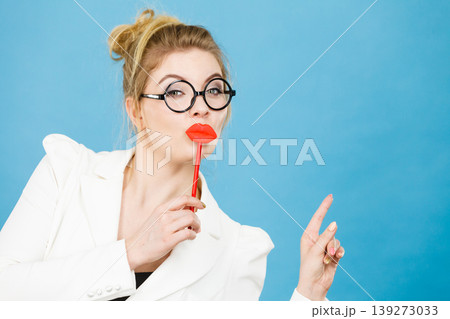 woman holds fake lips on stick pointing at copy space woman holds fake lips on stick pointing at copy space 139273033