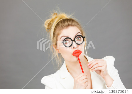Happy elegant woman holding carnival accessoies on stick 139273034