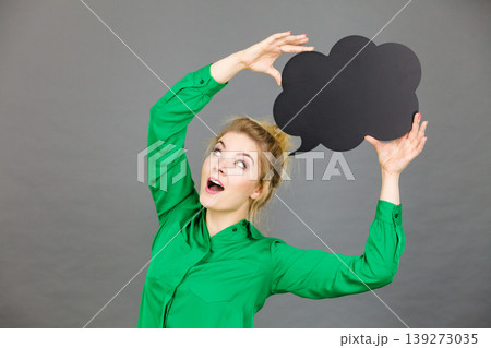 Happy woman holding black thinking bubble Happy woman holding black thinking bubble 139273035