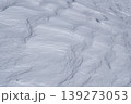 複雑な風の動きが描く雪原の風紋・重なり合う曲線が美しい白のテクスチャ背景 139273053