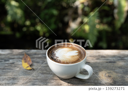 cappuccino on grunge old wooden table. and cozy atmosphere in the backyard garden 139273271