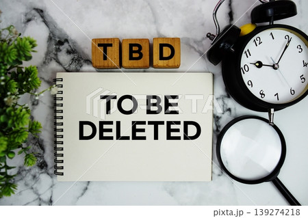 TBD To Be Deleted text with alarm clock and magnifying glass on marble background TBD To Be Deleted text with alarm clock and magnifying glass on marble background 139274218