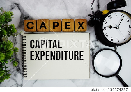 CAPEX Capital Expenditure text with alarm clock and magnifying glass on marble background 139274227