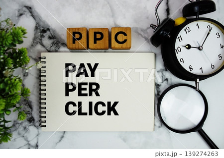 PPC Pay Per Click text with alarm clock and magnifying glass on marble background PPC Pay Per Click text with alarm clock and magnifying glass on marble background 139274263