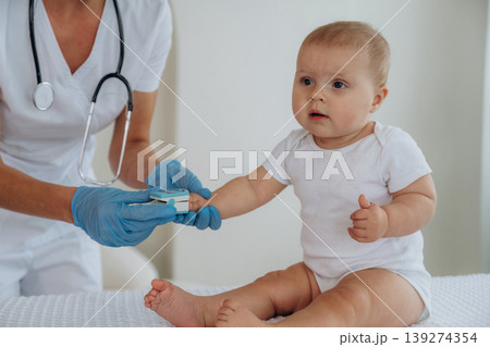 The oxygen in blood meter tool. Female doctor is taking care of little baby girl in the clinic 139274354
