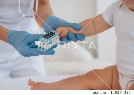 Oxygen content measuring. Close up view of little baby girl that is in appointment with doctor 139274359