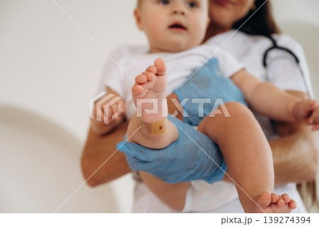 Holding kid in hands. Female doctor is taking care of little baby girl in the clinic Holding kid in hands. Female doctor is taking care of little baby girl in the clinic 139274394