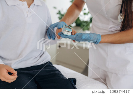 Finger is in oxygen content meter. Detailed close up view of boy with appointment in hospital with doctor Finger is in oxygen content meter. Detailed close up view of boy with appointment in hospital with doctor 139274417