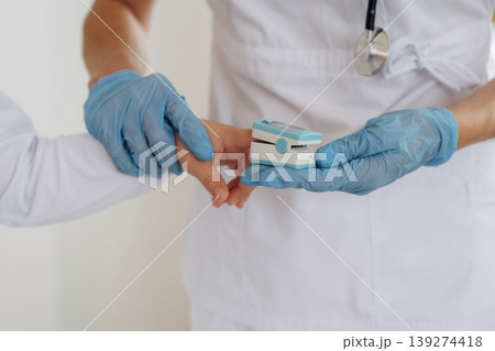 Finger is in oxygen content meter. Detailed close up view of boy with appointment in hospital with doctor Finger is in oxygen content meter. Detailed close up view of boy with appointment in hospital with doctor 139274418