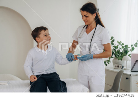 Measures oxygen content. Boy is in routine appointment in clinic with female doctor Measures oxygen content. Boy is in routine appointment in clinic with female doctor 139274419