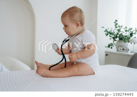 Female doctor is taking care of little baby girl in the clinic Female doctor is taking care of little baby girl in the clinic 139274445