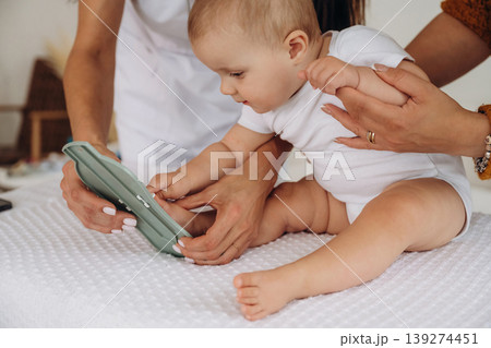 Board game, game for developing motor skills. Mother with her little baby daughter is in clinic with doctor at appointment Board game, game for developing motor skills. Mother with her little baby daughter is in clinic with doctor at appointment 139274451