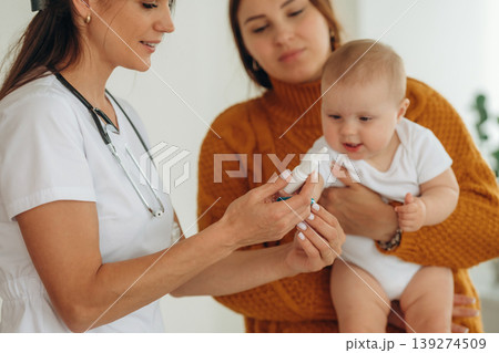 Medicine is in hands. Mother with her little baby daughter is in clinic with doctor at appointment Medicine is in hands. Mother with her little baby daughter is in clinic with doctor at appointment 139274509