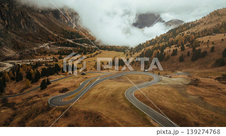 Twisted snake-like asphalt road. Pass near Cortina mountain. Aerial majestic view of popular place at autumn season, background Twisted snake-like asphalt road. Pass near Cortina mountain. Aerial majestic view of popular place at autumn season, background 139274768