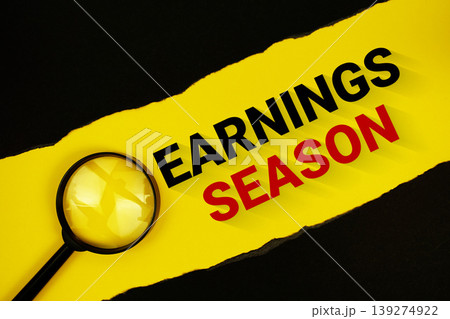 Earnings Season text on yellow with black paper torn ripped and magnifying glass 139274922