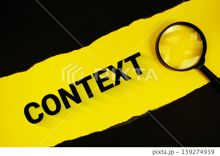 Context text on yellow with black paper torn ripped and magnifying glass 139274939