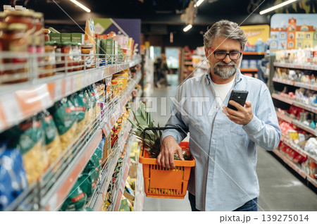 With big pineapple. A senior man is buying food in the grocery store With big pineapple. A senior man is buying food in the grocery store 139275014