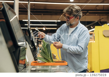Standing at the checkout. A senior man is buying food in the grocery store Standing at the checkout. A senior man is buying food in the grocery store 139275019