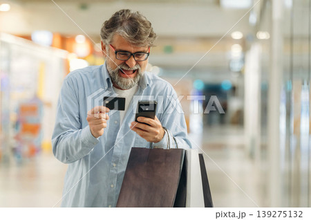 Process of online payment by using credit card and smartphone. Senior man is in the mall, shopping time conception 139275132