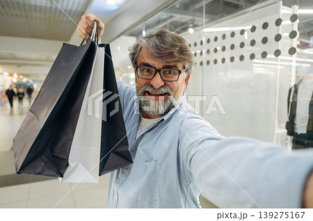 Selfie time, with packages. Senior man is in the mall, shopping time conception Selfie time, with packages. Senior man is in the mall, shopping time conception 139275167