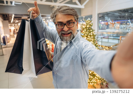 Selfie time, with packages. Senior man is in the mall, shopping time conception Selfie time, with packages. Senior man is in the mall, shopping time conception 139275212