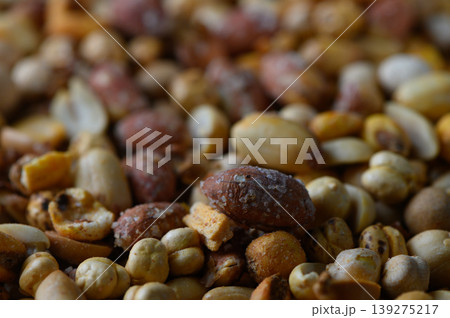 Mixed nuts spread across a rustic wooden surface inviting a sensory experience of textures and flavors 139275217