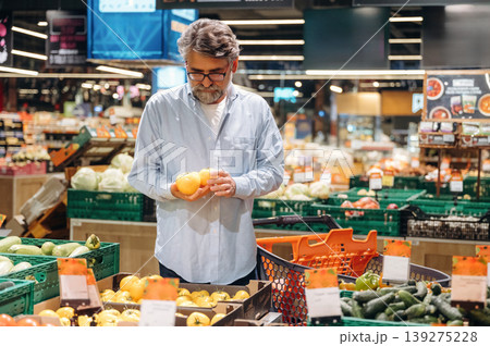 Vegetables section. A senior man is buying food in the grocery store Vegetables section. A senior man is buying food in the grocery store 139275228