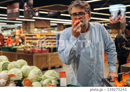 Vegetables section. A senior man is buying food in the grocery store Vegetables section. A senior man is buying food in the grocery store 139275243