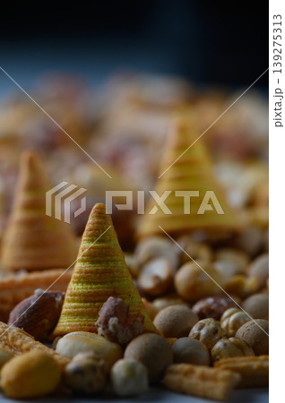 Deliciously crafted conical snacks surrounded by a medley of nuts and treats on a rustic surface Deliciously crafted conical snacks surrounded by a medley of nuts and treats on a rustic surface 139275313
