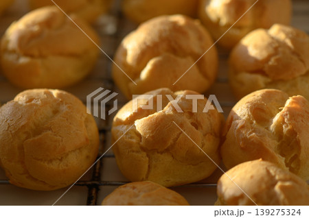 Golden pastry puffs freshly baked and cooling on a wire rack in a warm kitchen 139275324
