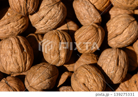 Walnuts nestled in a rustic display showcasing natural textures and earthy tones during a sunlit afternoon harvest Walnuts nestled in a rustic display showcasing natural textures and earthy tones during a sunlit afternoon harvest 139275331