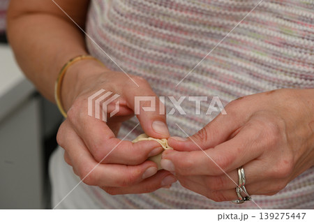Skillful hands crafting intricate designs using delicate materials in a bright workshop 139275447