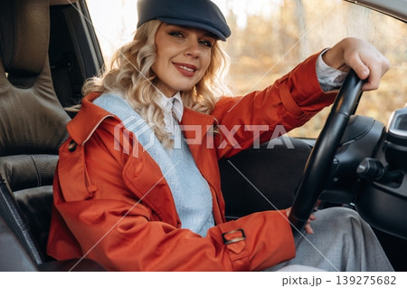 Comfortable interior, relax. Happy blonde woman is sitting her electric car 139275682