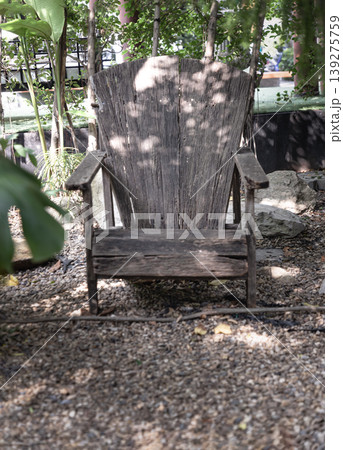 a solitary wooden armchair crafted from deeply weathered, silvered timber stands as a rustic monument to quietude and the slow passage of time. a solitary wooden armchair crafted from deeply weathered, silvered timber stands as a rustic monument to quietude and the slow passage of time. 139275759