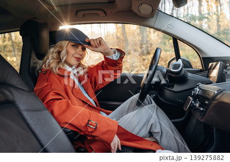 Comfortable interior, relax. Happy blonde woman is sitting her electric car 139275882