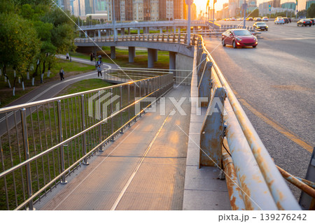 Metal wheelchair ramp outdoor for accessibility on pedestrian bridge. Infrastructure for city urban mobility. Equal opportunity entrance for disabled person with mobility aid in modern street. 139276242