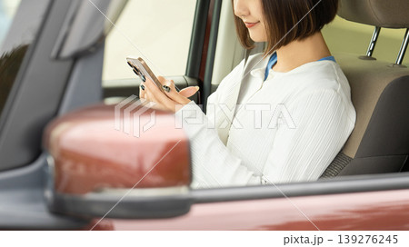 車に乗ってスマートフォンを使う女性 車に乗ってスマートフォンを使う女性 139276245